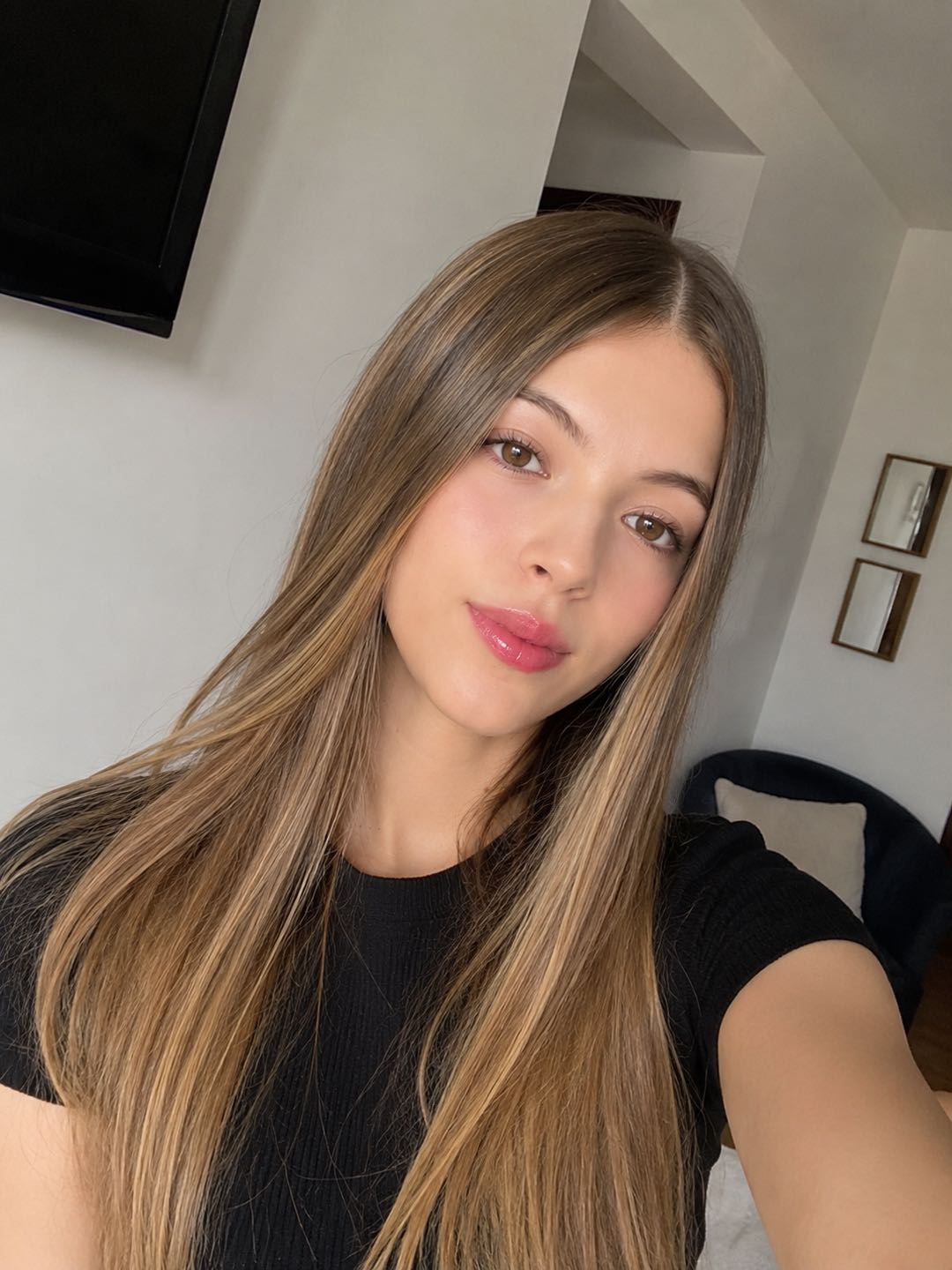 Woman with long light brown hair taking a selfie