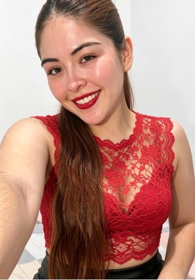 Smiling woman with long dark hair in a red lace top