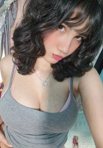 Woman with wavy dark hair in a grey top