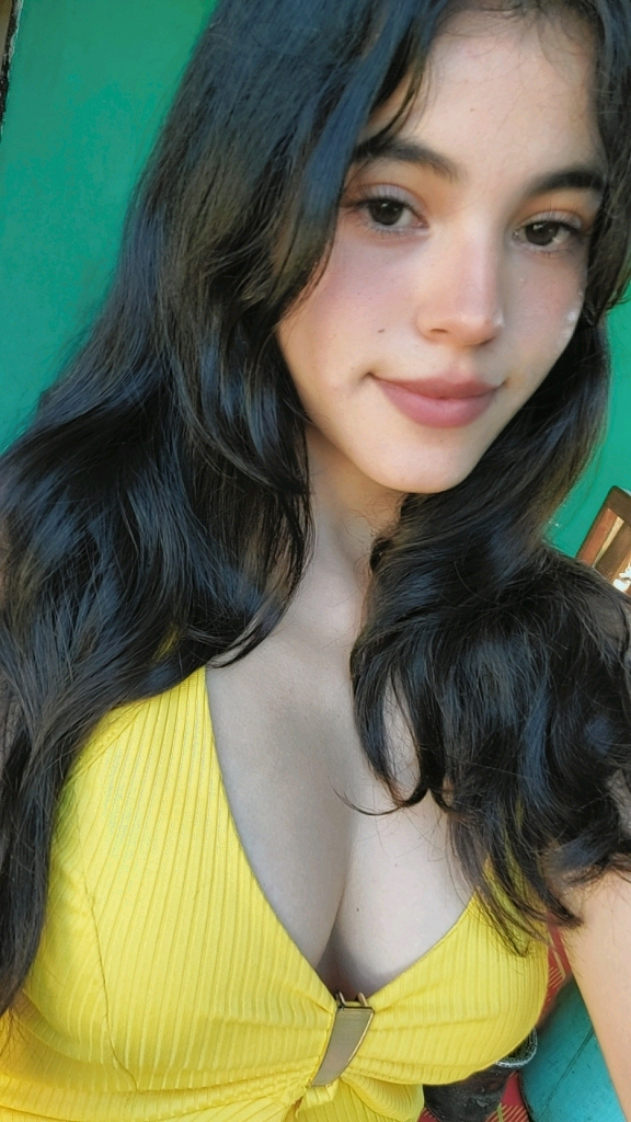 Woman with long dark hair against a green wall