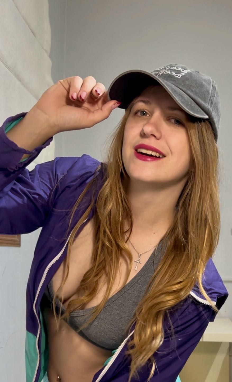 Woman in a grey cap and purple jacket smiling